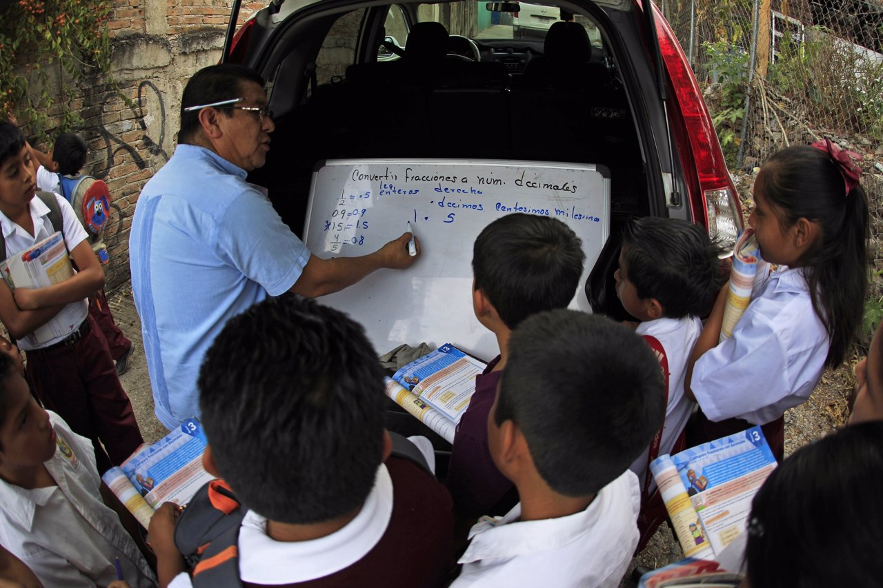 A teacher from Emiliano Zapata Elementary School teaches students on the street 