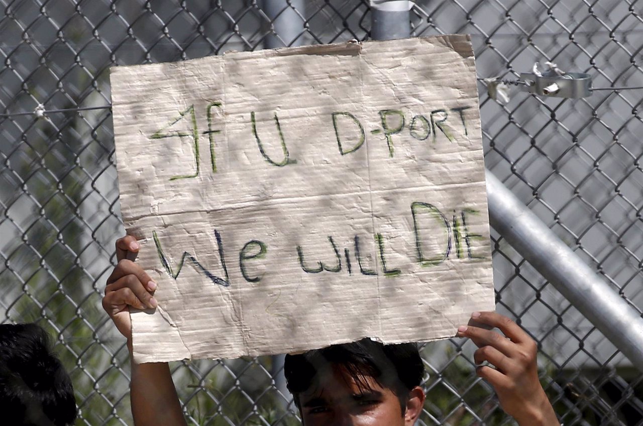 Un refugiado con una pancarta en un centro de la isla de Lesbos