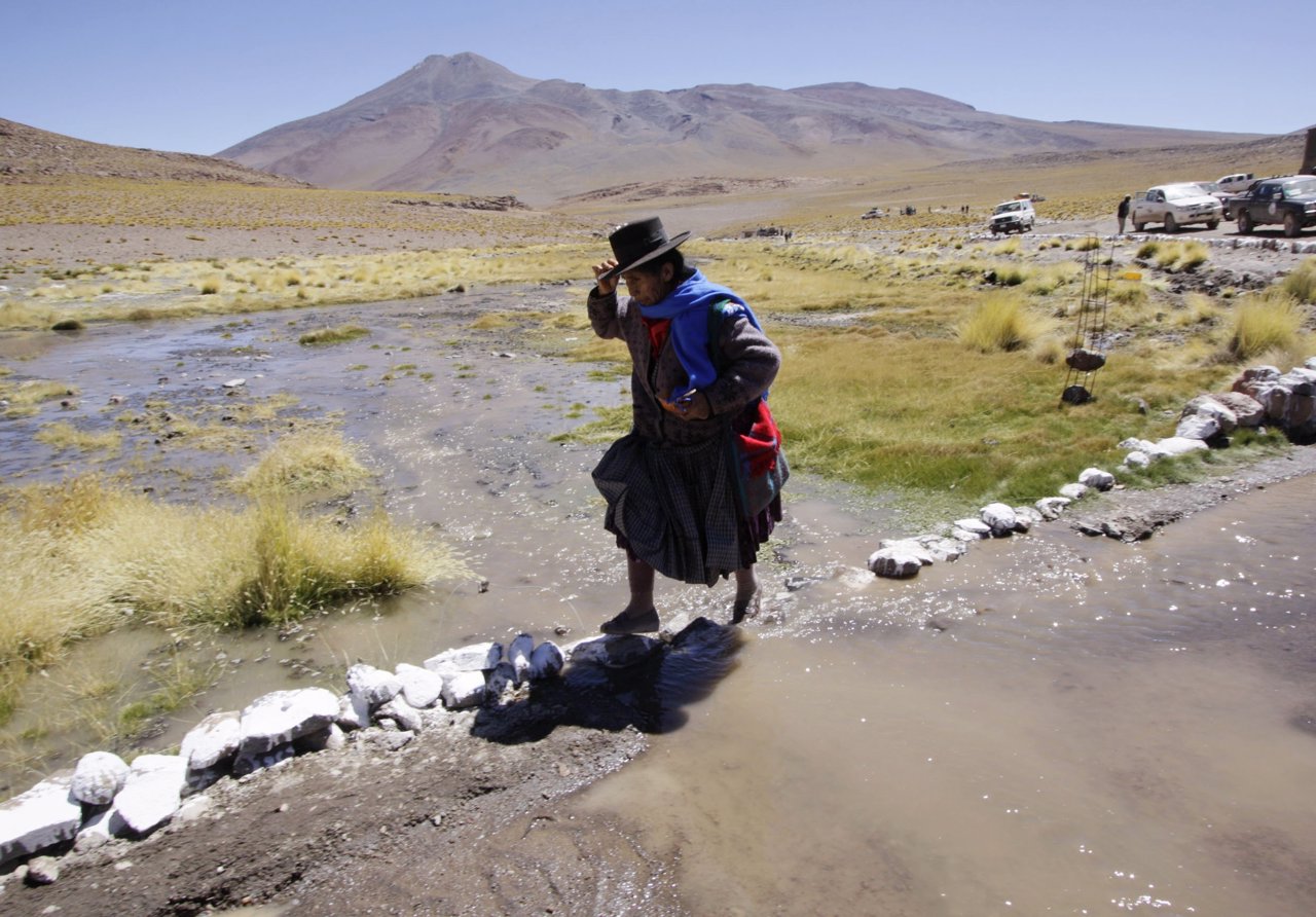 Una mujer curza el río Silala en la frontera entre Chile y Bolivia
