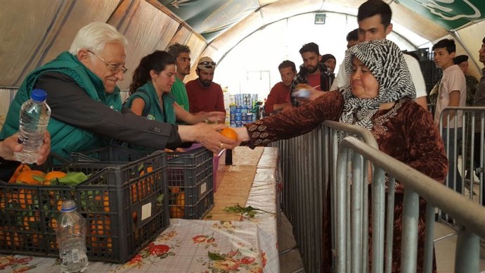 El Padre Ángel y voluntarios, dando comida a refugiados