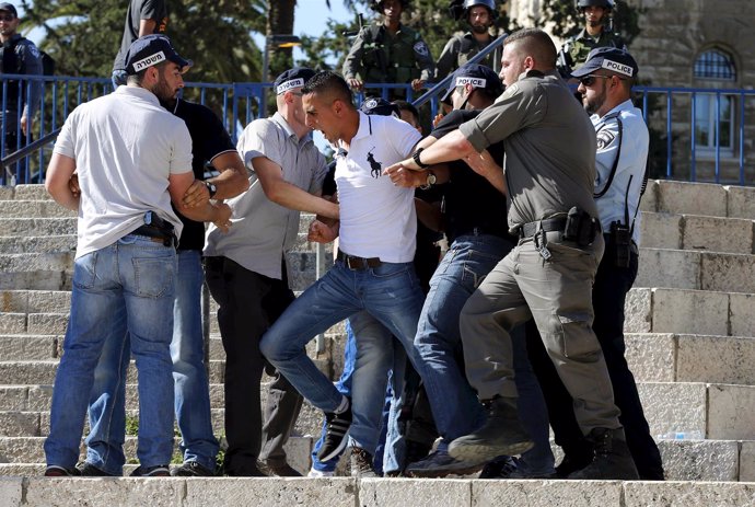 Policías israelíes detienen a un joven palestino.
