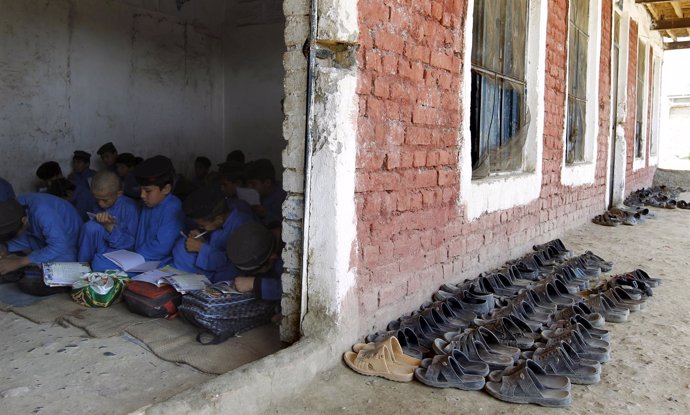Children of Afghan refugees attend a class in their school at an Afghan refugee 