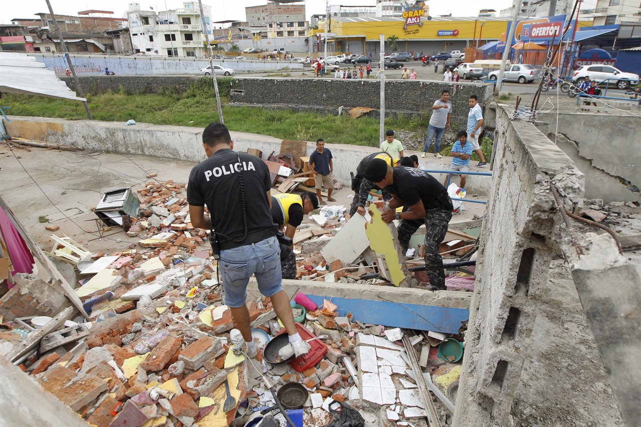 Police officers search through debris after an earthquake struck off Ecuador's P