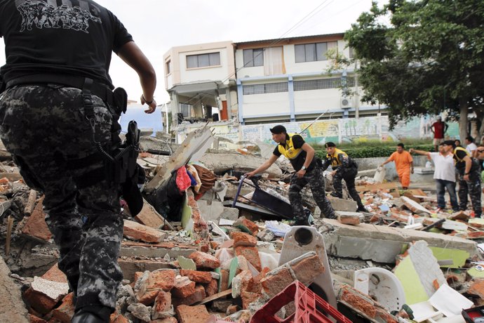 Red Cross members, military and police officers work at a collapsed area after a
