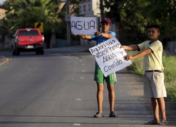 Afectados por el terremoto en  Manta con cartel "Agua"