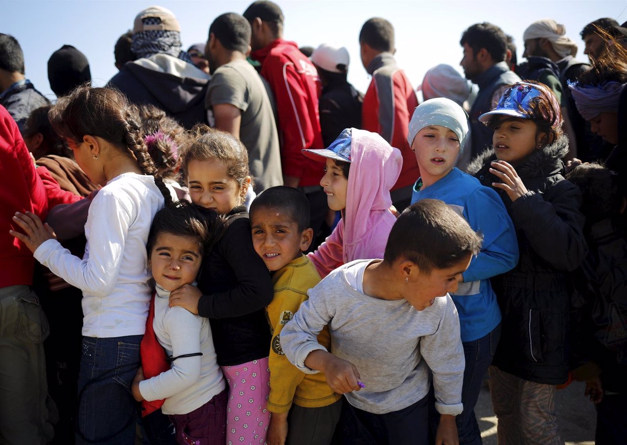 Niños refugiados esperan a recibir ayuda en Idomeni