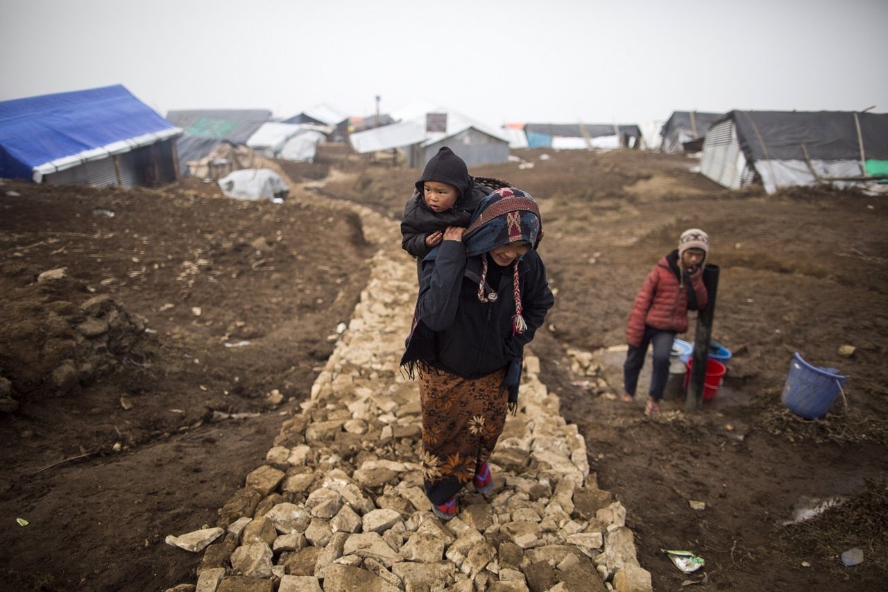 Una mujer con su hijo en un campamento para desplazados tras terremoto de Nepal