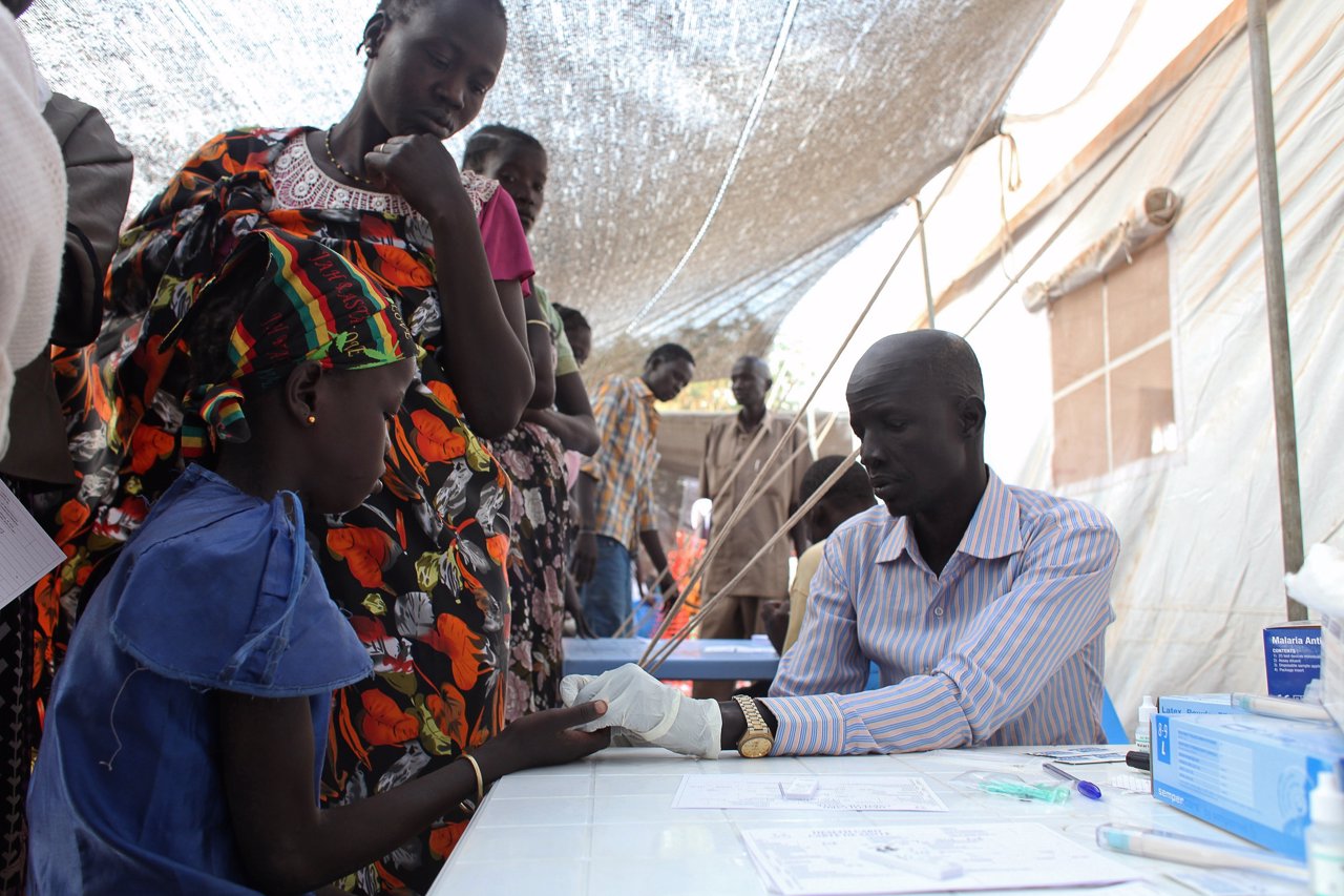 A displaced girl is tested for malaria in Tomping camp, where some 17,000 displa