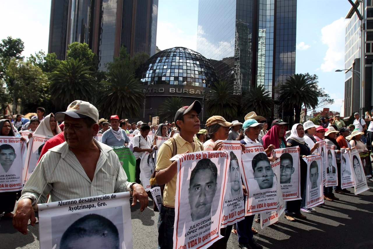 Relatives carry photos of some of the 43 missing students of the Ayotzinapa teac