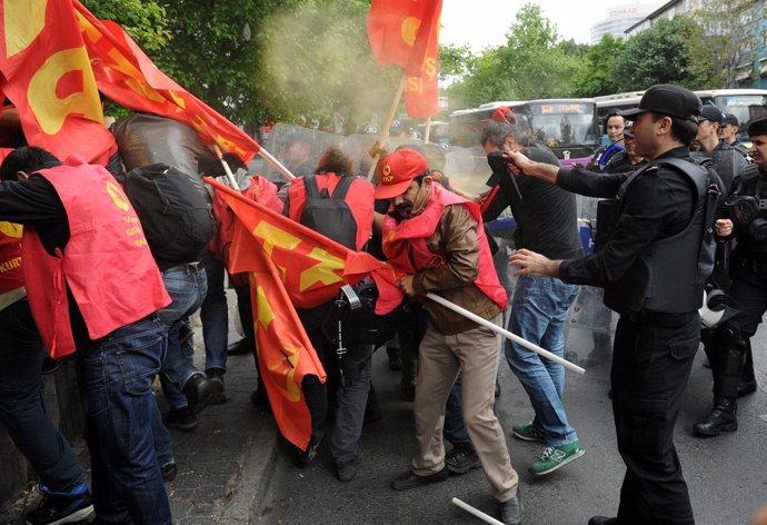 Un policía turco usando un pulverizador de pimienta contra manifestantes