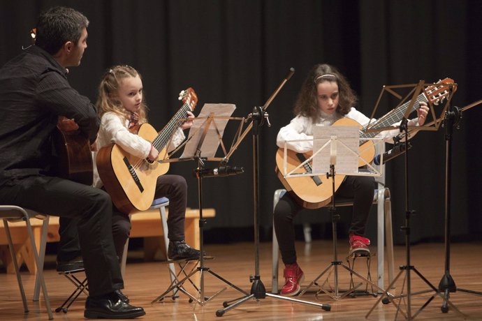 Niños tocando la guitarra en la escuela de música de Camargo 