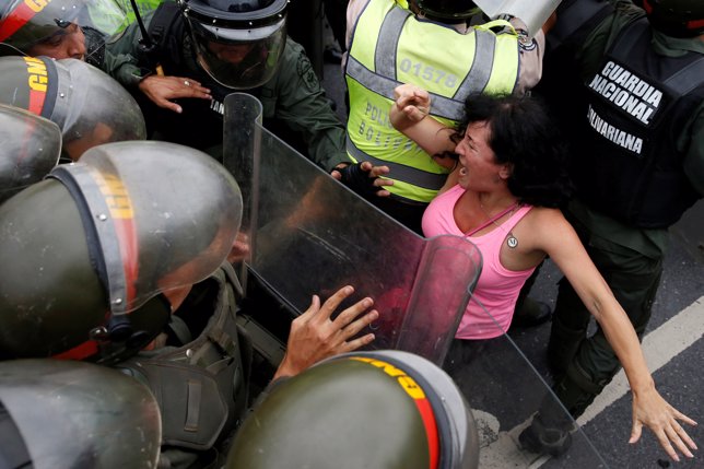 Manifestante y fuerzas de seguridad venezolanas