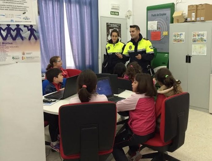 Niños escuchando las explicaciones de dos policias locales de Moriles