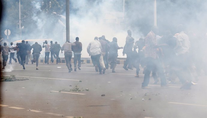 Kenyan opposition CORD supporters run after riot police lobbed teargas canisters