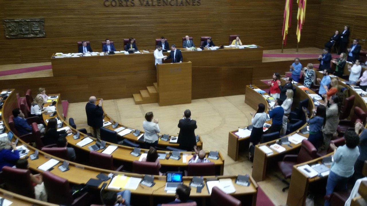 Ferri entrega a Puig una pulsera LGTB en la tribuna de las Corts