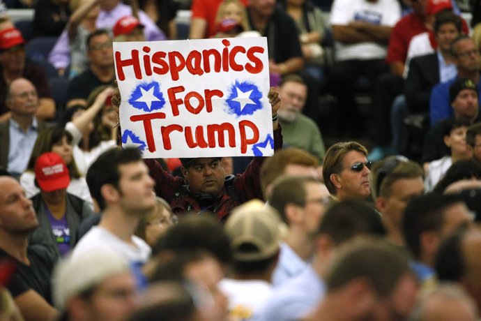 Un seguidor de Trump sostiene un cartel de "Hispanics for Trump en un mitin 