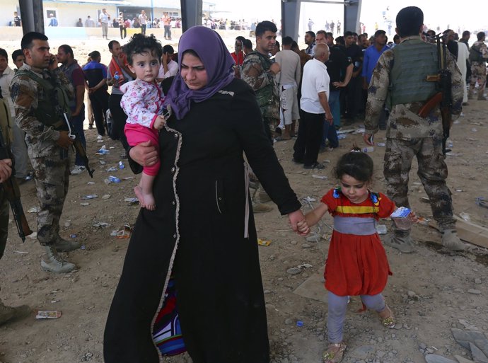 Familias de desplazados huyen de la violencia en Mosul