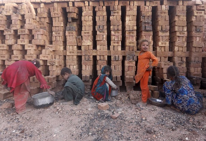 Niños afganos trabajando en una fábrica de ladrillos