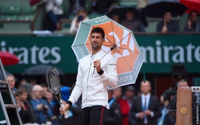 Novak Djokovic con un paraguas en Roland Garros