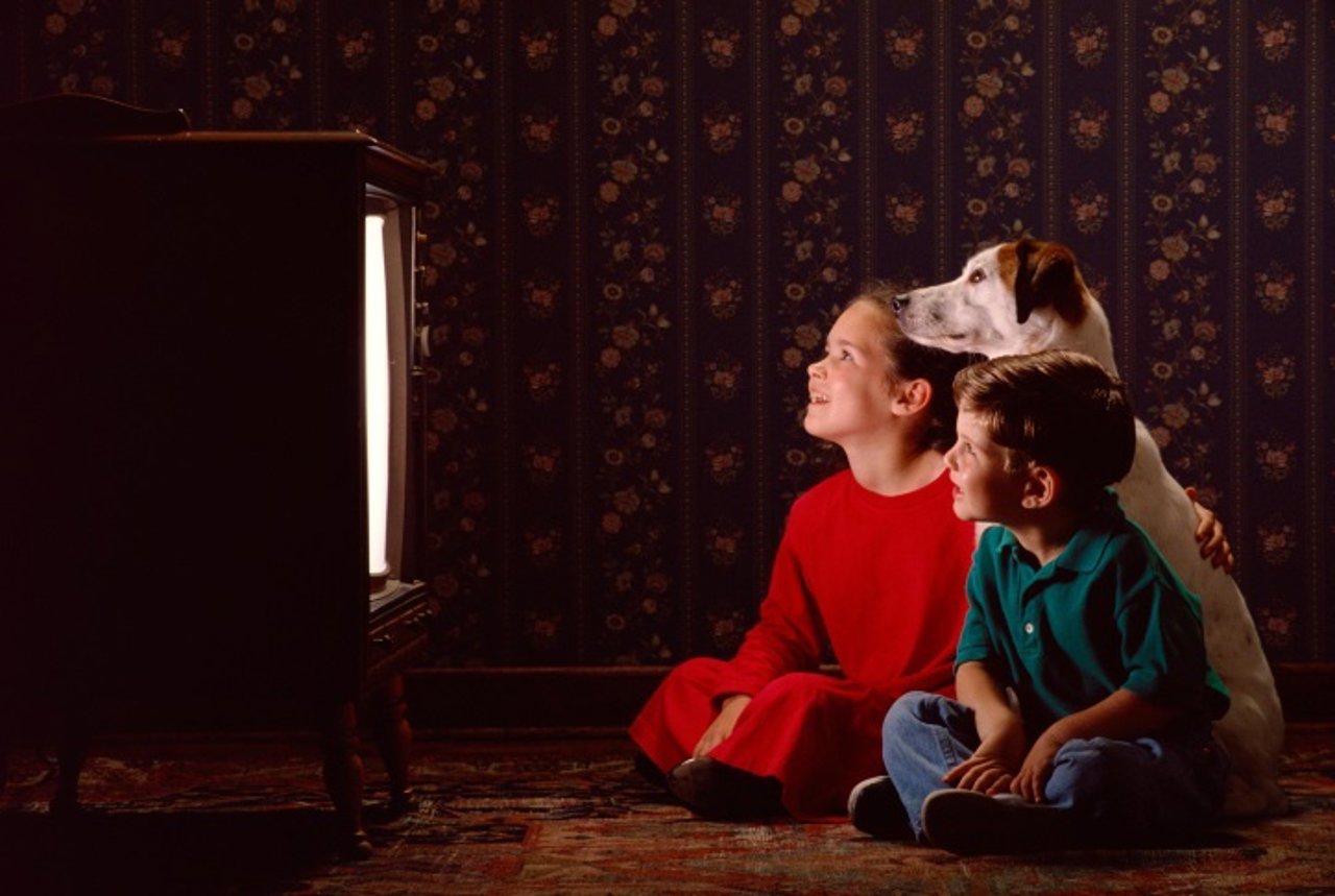 Niños viendo la televisión con un perro