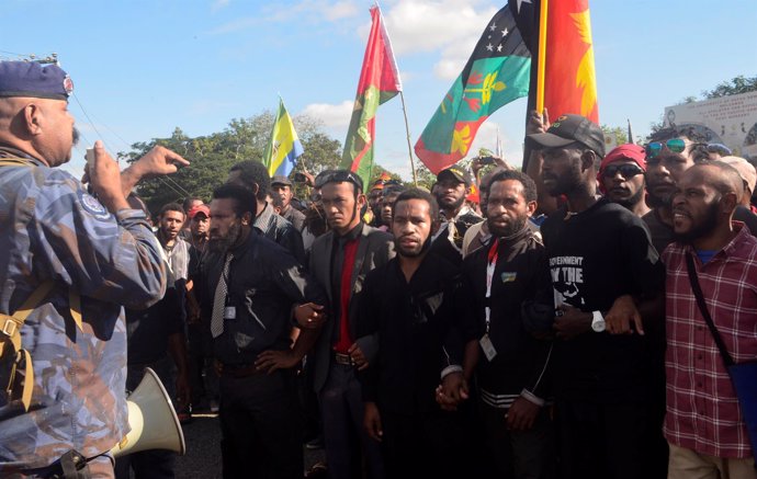 A Papua New Guinea police special services division officer talks through a mega