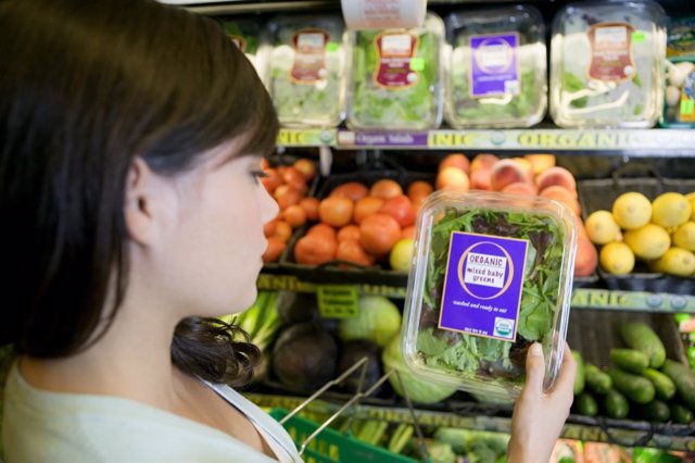Mujer en el supermercado comprando verduras orgánicas