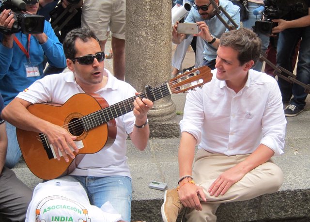 Rivera escucha a un músico por las calles de Salamanca