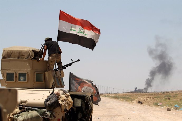 Miembros de las fuerzas iraquíes conducen un vehículo en las afueras de Faluya