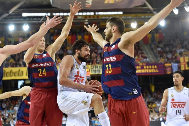 Sergio Llull ante dos jugadores del Barça en el Palau