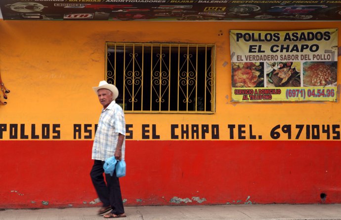 A resident walks past the "Chapo" roast chicken restaurant 