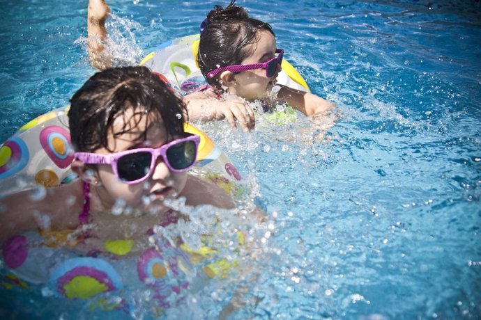 Niñas en la piscina con gafas de sol