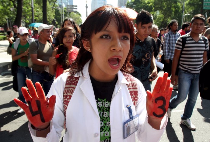 Un manifestante, con un 4 y un 3 marcha por las calles de México DF 