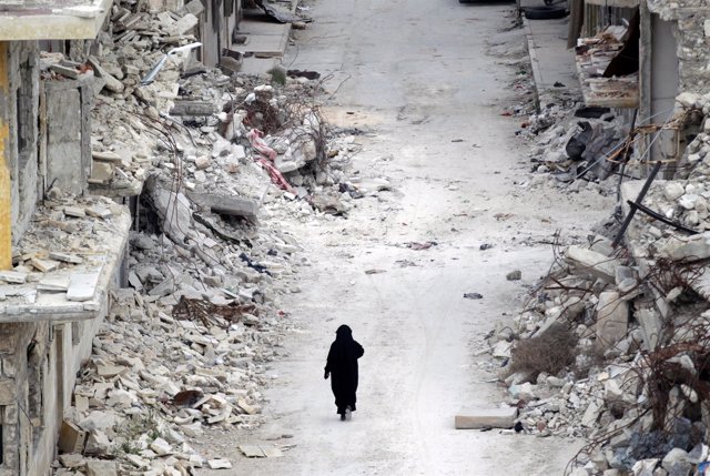 Una mujer camina entre escombros en Numan (Idlib)
