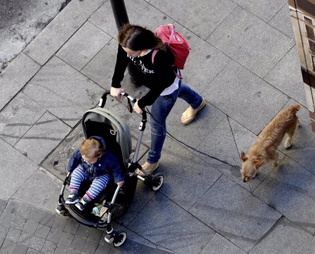 Mujer paseando en la calle, niño, niña, familia, carrito, conciliación