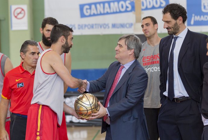 Navarro le entrega un balón a Cardenal en presencia de Garbajosa