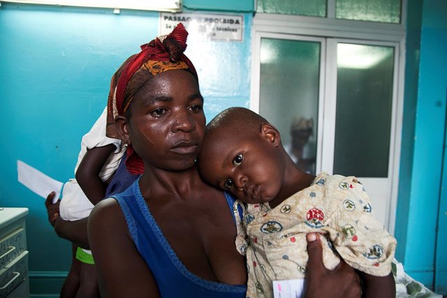 Un mujer sostiene a su hijo en brazos, enfermo de fiebre amarilla en Angola