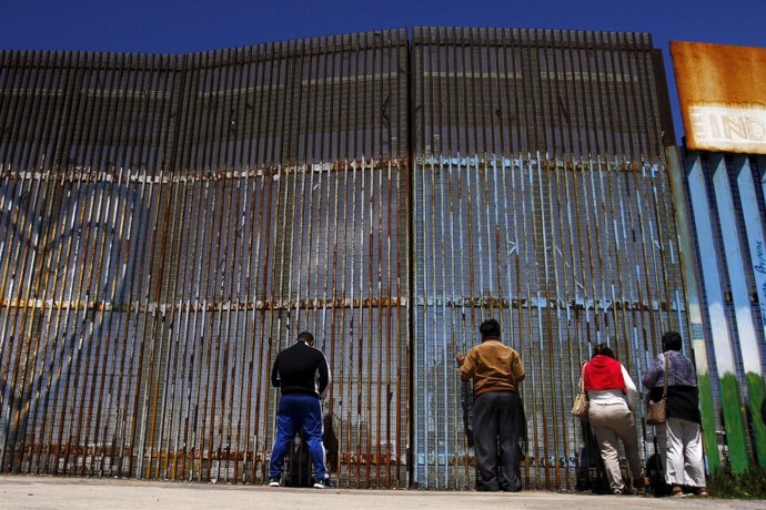 Una familia en la valla fronteriza entre México y Estados Unidos