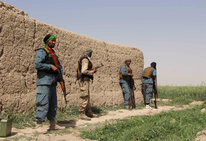 Policía afgana vigila durante una batalla