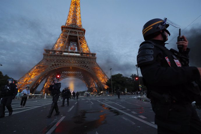 Un agente antidisturbios frente a la Torre Eiffel de París