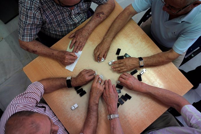 Pensionistas juegan al dominó en un centro de mayores
