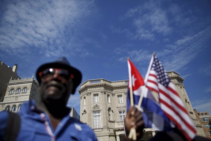 Newly reopened Cuban embassy is seen in the background as a man holds U.S. And C