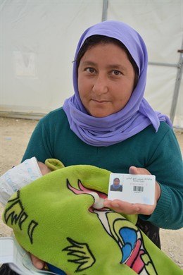 Refugiada enseñando su tarjeta LMMS de World Vision