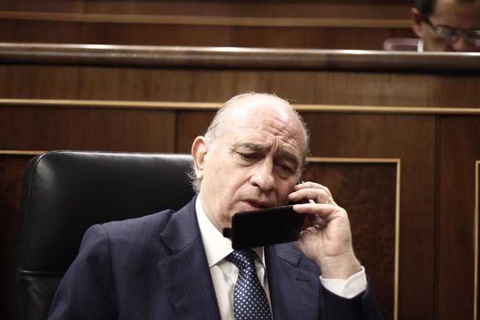 Jorge Fernández Díaz, hablando por teléfono en el hemiciclo