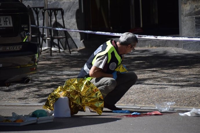 Un agente obsreva restos en el lugar del tiroteo