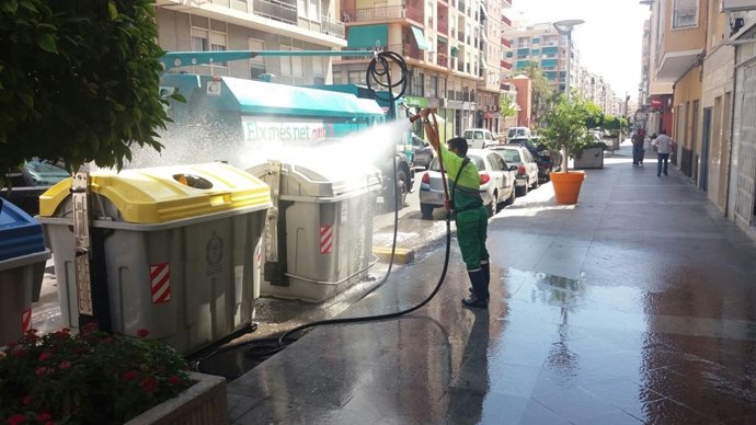 Un trabajador limpia uno de los contenedores