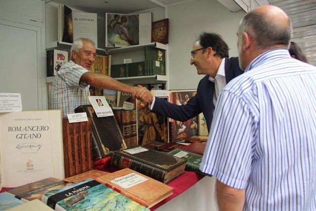 Alfonso Polanco saluda a uno de los libreros de la Feria.