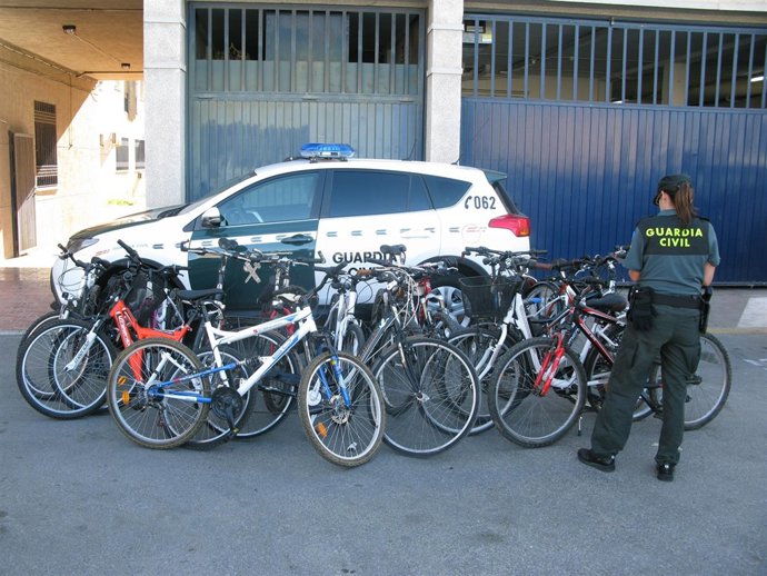 Una agente junto a las bicicletas recuperadas