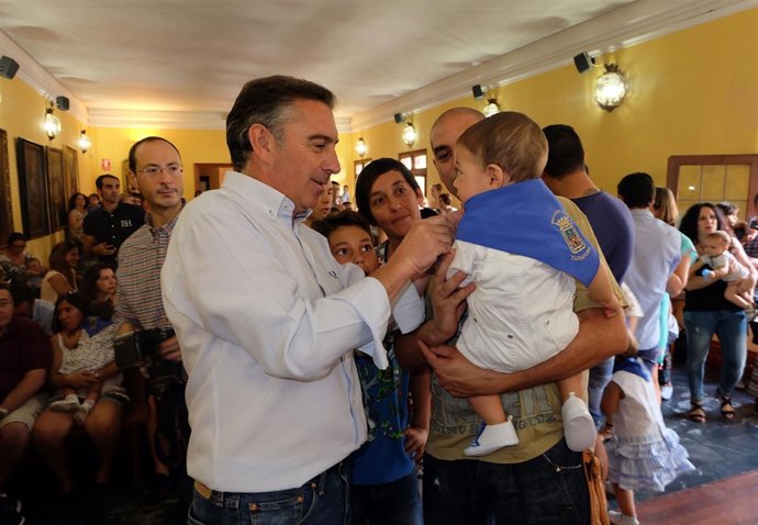 El alcalde de Tarazona, Luis María Beamonte, impone el pañuelico a un bebé.