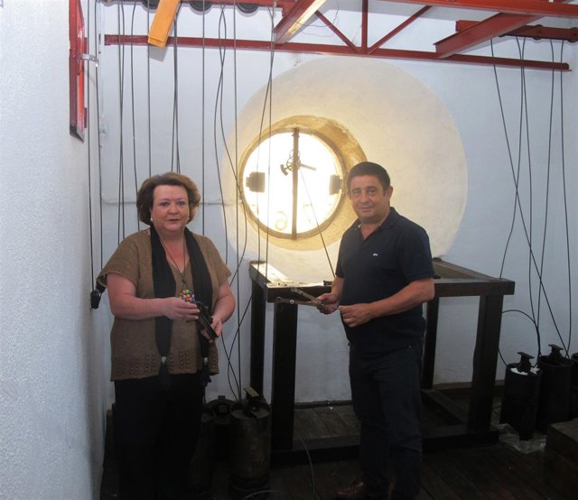 Francisco Reyes, junto con Pilar Parra, en el interior del mecanismo del reloj.