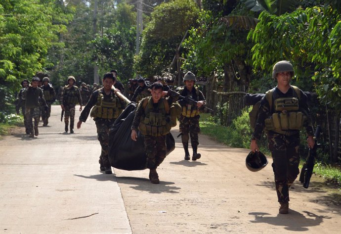 Soldados filipinos cargan con los cuerpos de víctimas de la campaña antidroga